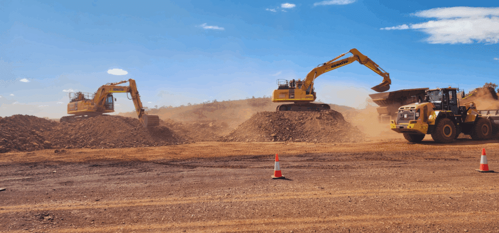 Two Komatsu excavators loading soil into dump truck during earthworks on Western Australia civil construction site for mining projects